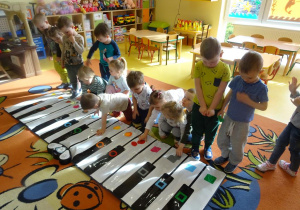 Dzieci dopasowują swoje figury geometryczne do tych znajdujących się na klawiszach Kolorpiano.